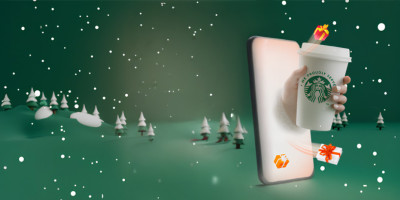 theme de noel avec un smartphone et une tasse starbcusk qui sort du smartphone